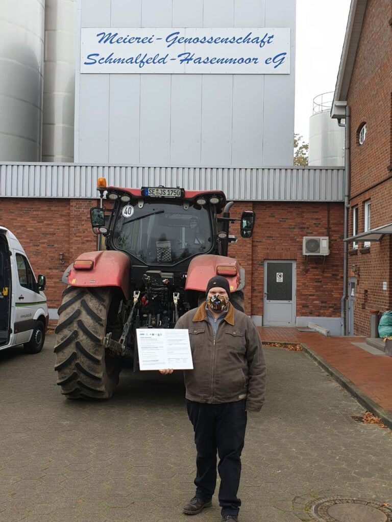 Bauern stehen vor Schlepper und der Meierei Schmalfeld mit dem Forderungspapier