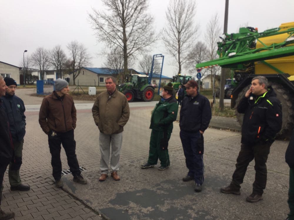 Bauern stehen in der Auffahrt von Müritz Milch